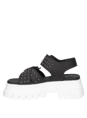 Sandalia de cuero negro, diseño moderno con tachas y taco estilizado.
