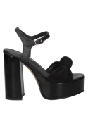 Elegante sandalia negra de cuero con lazo decorativo y correa ajustable al tobillo, perfecta para ocasiones especiales.