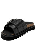 Calzado de mujer en cuero negro reptil, hebilla funcional y suela chunky, ideal para looks casuales y formales.