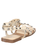 Sandalia de mujer en cuero beige con hebilla lateral y detalles metálicos, perfecta para ocasiones informales.