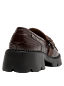 Elegante mocasín de cuero café con correa decorativa metálica, perfecto para ocasiones informales y semiformales.