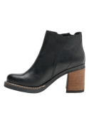 Moderno botín de cuero negro con tachas metálicas, perfecto para un estilo casual y cómodo al caminar.
