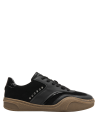 zapatilla deportiva negra de cuero con suela café y aplicaciones metálicas, ideal para estilo casual femenino