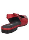 Detalle de ojales asimétricos en la parte delantera del zapato de cuero rojo.