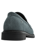 Mocasín de cuero celeste para mujer con hebilla metálica, estilo casual y suela negra contrastante.