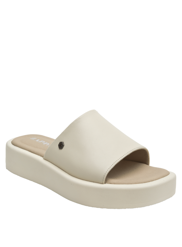 Sandalia beige de cuero para mujer combinada con jeans rectos, mostrando un look casual relajado.