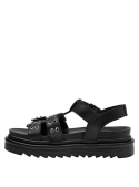 Textura del cuero negro en sandalia casual de mujer, destacando su versatilidad.