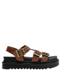 Acabado limpio de sandalia camel con suela plana y detalles en cuero para estilo casual.