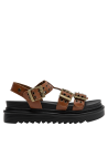 Acabado limpio de sandalia camel con suela plana y detalles en cuero para estilo casual.