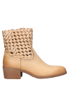 Botín casual de cuero beige con estilo adaptable, combinable con prendas como chaquetas o blusas.
