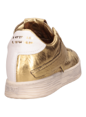 Zapatilla femenina oro de cuero, perfil limpio y costuras definidas.
