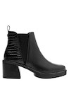 Botín urbano de cuero negro para mujer, ideal para un look audaz con vestido fluido.