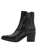 Botín negro de cuero para mujer, ideal para combinar con vestidos ajustados y jeans desgastados.