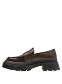 Mocasín de cuero en color moro, detalle metálico que aporta un toque moderno y audaz.