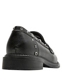 3Mocasín de cuero negro con texturas brillantes, diseñado para realzar cualquier atuendo femenino.