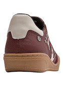 Zapatilla burdeos de mujer con tachas que aportan carácter y estilo moderno.
