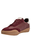 Zapatilla urbana burdeos de cuero suave con textura de gamuza y detalles metálicos.