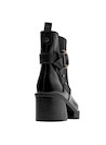 Botín negro brillante que resalta el carácter moderno, ideal para combinar con vestidos midi.