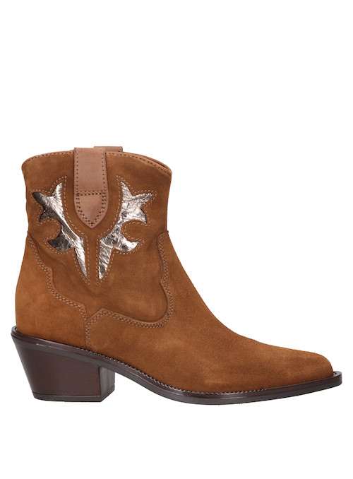 Botín vaquero en cuero camel, destacando su corte distintivo y estilo rockero.