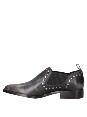 Zapato de cuero con tachas sutiles en los bordes, ideal para looks urbanos.
