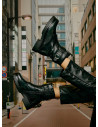 Botín negro de cuero para mujer, estilo urbano, ideal para looks contemporáneos.