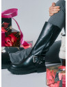 Bota de cuero negro para mujer con diseño urbano y cinturón decorado con tachas.