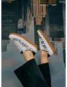 Zapatilla blanca de cuero para mujer con detalle de cebra, estilo urbano y diseño moderno.