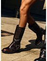 Bota de cuero moreno para mujer con diseño urbano y detalles metálicos.