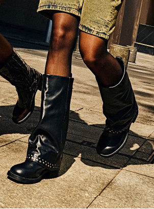 Botas urbanas de cuero negro para mujer con detalles metálicos que destacan su diseño audaz.