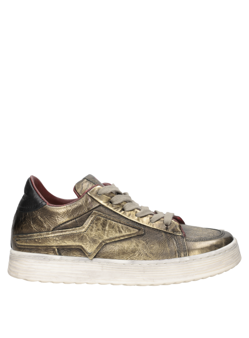 Zapatilla de mujer en cuero suave dorado, perfecta para combinar con jeans ajustados y blusas elegantes.