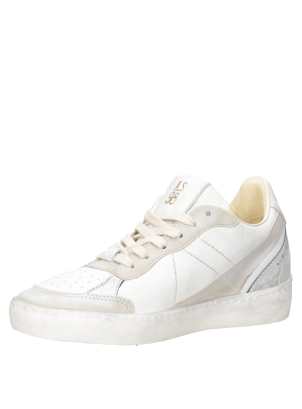 Zapatilla de mujer en blanco con estrella lateral de cuero plateado desgastado.
