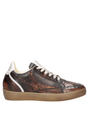 Zapatilla femenina en cuero brillante, con bordes contrastantes que realzan su estilo vanguardista.